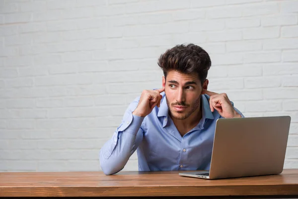 Jovem Homem Negócios Sentado Trabalhando Laptop Cobrindo Ouvidos Com Mãos — Fotografia de Stock