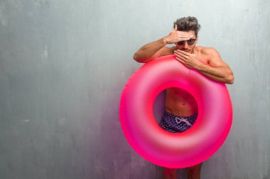 Gizleme ve şaşı bir boşluk seyir bir grunge duvara bir mayo giyen genç atletik adam