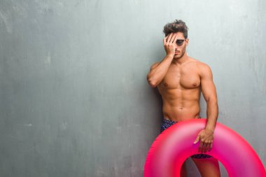 Bir grunge duvara bir mayo giyen genç atletik erkek endişeli ve bunalmış, unutkan, bir şeyi ifade bir hata yapılmış olması, şok fark