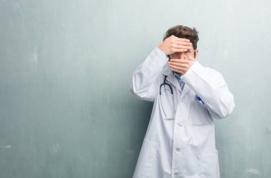 Gizleme ve gözlerini kısarak samimi bir doktor adam bir boşluk seyir bir kopya alanı ile bir grunge duvara