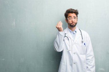 Genç dostu Doktor adam tipik İtalyan jest, gülümseyen ve düz ileriye baktığımızda, simge veya el, çok doğal bir ifadeyle yapıyor bir kopya alanı ile bir grunge duvara