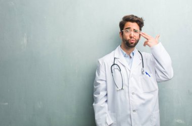 Duygu üzgün ve korkmuş bir silah parmak ile şekillendirme genç dostu Doktor adam intihar jest yapma bir kopya alanı ile bir grunge duvara