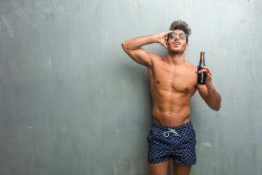 Bir grunge karşı bir mayo giyen genç atletik erkek duvar kontrolden çıktı, özgürlük ve vahşi ifade etmek komik deli deli ve umutsuz, çığlık