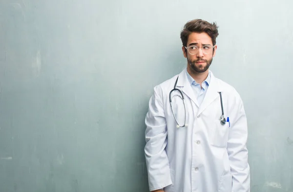 Young Friendly Doctor Man Grunge Wall Copy Space Doubting Confused — Stock Photo, Image