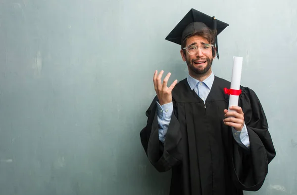 Junger Mann Mit Hochschulabschluss Vor Einer Grunge Wand Mit Kopierraum — Stockfoto