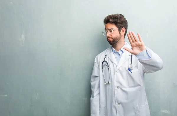 Junger Freundlicher Arzt Gegen Eine Grunge Wand Mit Kopierraum Ernst — Stockfoto