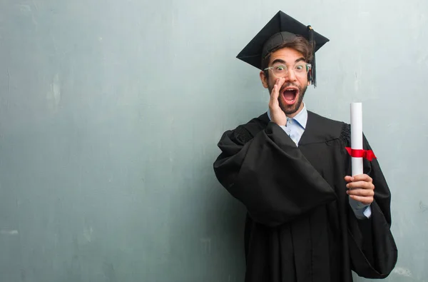 Joven Graduado Contra Una Pared Grunge Con Espacio Copia Gritando —  Fotos de Stock