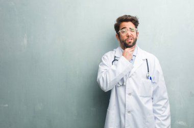 Boğaz, virüs yüzünden, hasta ile kopya alanı ile bir grunge duvara genç dostu Doktor adam yorgun ve çaresiz