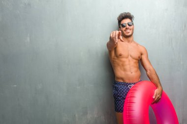 Bir grunge karşı bir mayo giyen genç atletik erkek bağırarak, gülen ve başka bir, kavramı alay alay duvar ve uncontrol