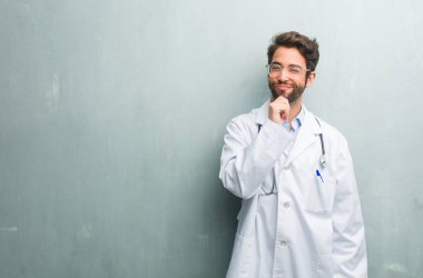 Genç dostu Doktor adam düşünme ve bakılması, hakkında bir fikir, karışık bir kopya alanı ile bir grunge duvara bir çözüm bulmaya çalışıyorum