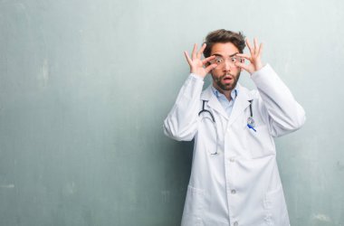 Genç dostu Doktor adam bir kopya alanı ile bir grunge duvara şaşırttı ve şok, kazanmak kavramı geniş gözlü, heyecanlı bir teklif veya yeni bir iş arıyorum