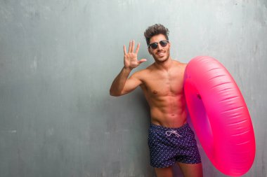 Sayma, kavramı matematik, kendinden emin ve neşeli bir grunge duvar gösteren sayı beş, sembol karşı bir mayo giyen genç atletik adam