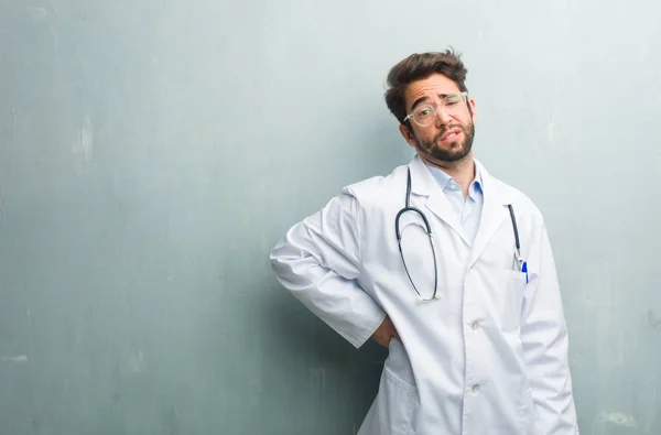 Jovem Médico Amigável Homem Contra Uma Parede Grunge Com Espaço — Fotografia de Stock