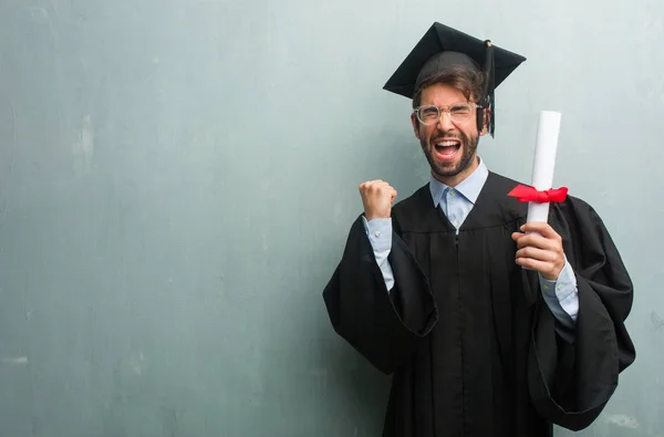 Junger Mann Mit Hochschulabschluss Vor Einer Grunge Wand Mit Kopierraum — Stockfoto