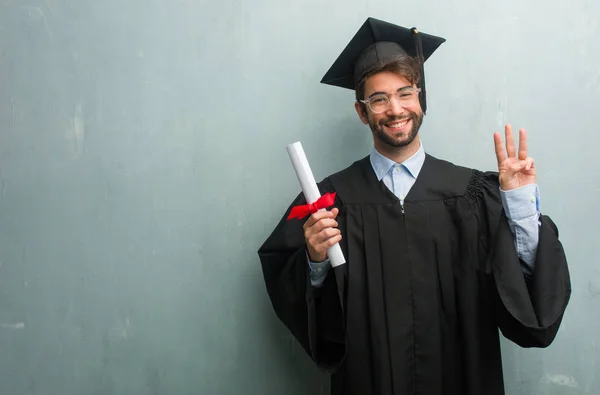 Young graduated man against a grunge wall with a copy space showing number three, symbol of counting, concept of mathematics, confident and cheerful