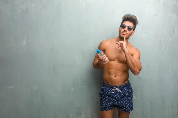 Young Athletic Man Wearing Swimsuit Grunge Wall Thinking Looking Confused — Stock Photo, Image