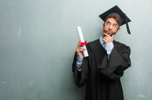 Young Graduated Man Grunge Wall Copy Space Thinking Looking Confused — Stock Photo, Image