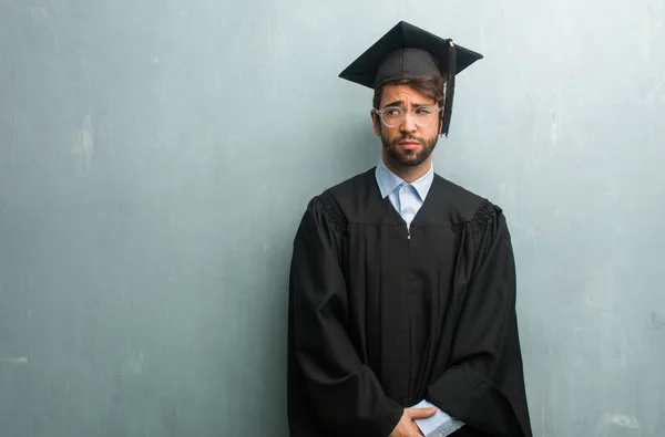 Young Graduated Man Grunge Wall Copy Space Doubting Confused Thinking — Stock Photo, Image