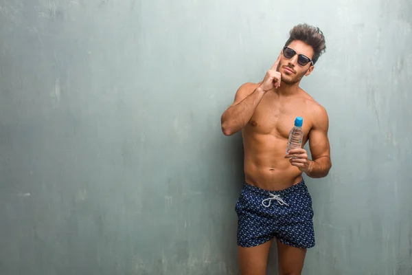 Joven Atlético Usando Traje Baño Contra Una Pared Grunge Pensando —  Fotos de Stock