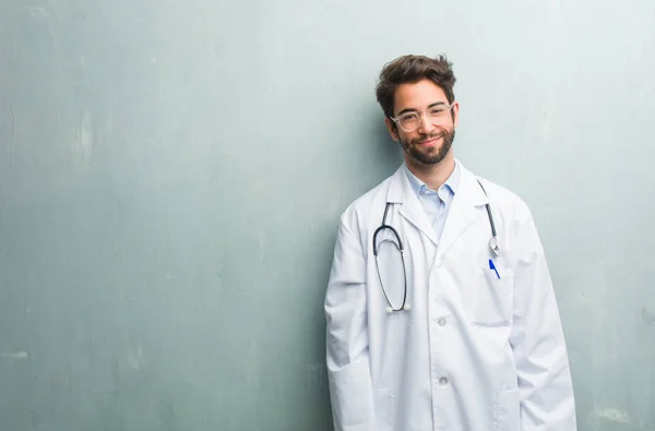 Jovem Médico Amigável Homem Contra Uma Parede Grunge Com Espaço — Fotografia de Stock