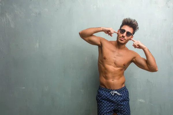 Young Athletic Man Wearing Swimsuit Grunge Wall Covering Ears Hands — Stock Photo, Image