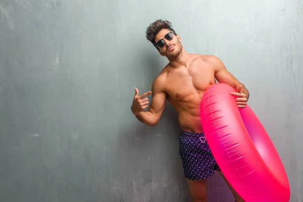 Young Athletic Man Wearing Swimsuit Grunge Wall Proud Confident Pointing — Stock Photo, Image