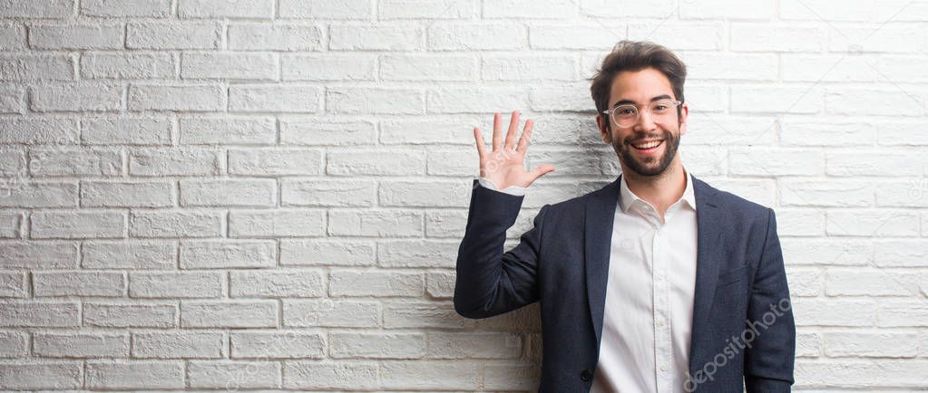 Young friendly business man showing number five, symbol of counting, concept of mathematics, confident and cheerful