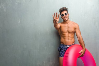 Gösterilen dört numaralı, sayma sembolü, kavramı matematik, kendinden emin ve neşeli bir grunge duvara bir mayo giyen genç atletik adam