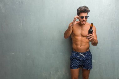 Öfkeli, negatif ve çılgın çığlık bir grunge duvara çok kızgın ve üzgün, çok gergin bir mayo giyen genç atletik adam