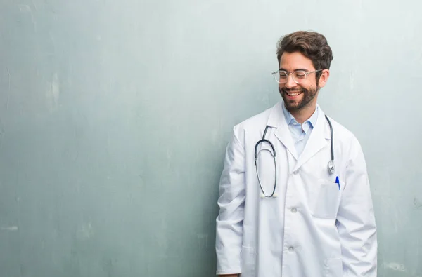 Jovem Médico Amigável Homem Contra Uma Parede Grunge Com Espaço — Fotografia de Stock