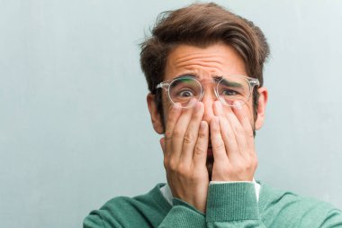 Genç yakışıklı girişimci adam yüz closeup çok korkmuş ve korkuyor, bir şey, acı çığlıkları ve açık göz, çaresizlere delilik kavramını