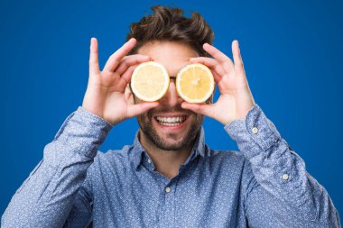 Genç adam gözleri mavi zemin üzerine limon ile kaplama