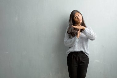 Bir zaman aşımı jest yapma genç Hintli kadın yorgun ve bıkkın, grunge duvara bir iş stresi nedeniyle, zaman kavramı son verilmeli