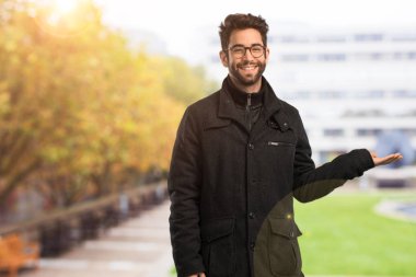 Genç adam bir şey tutuyor.