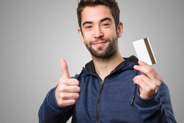 Junger Mann Mit Kreditkarte Und Okay Geste Auf Grauem Hintergrund — Stockfoto