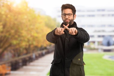 Dur bir jest yapan genç erkek