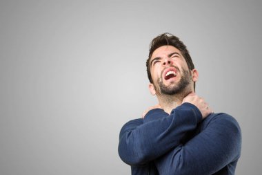 Genç adam bir sırt ağrısı gri arka plan üzerinde olması