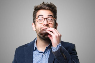 Genç adam gri arka plan üzerinde bir lokma yeme