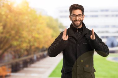 Genç adam bir şey tutuyor.