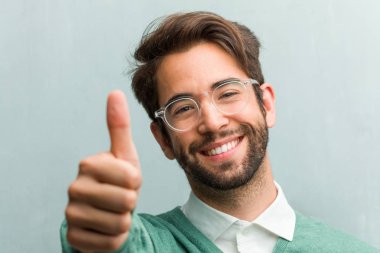 Genç yakışıklı girişimci adam neşeli ve heyecanlı, gülümsemek gülümseyen yüz ve onu başparmak, başarı ve onay, kavram yükselterek jest ok