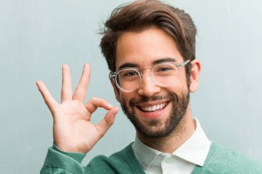 Genç yakışıklı girişimci adam yüz closeup neşeli ve kendine güvenen yapıyor Tamam jest, heyecanlı ve çığlık, kavram onayı ve başarı