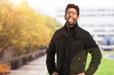 Dilini gösteren genç adam.