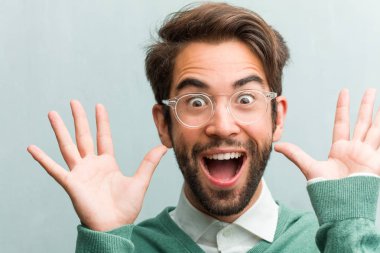 Genç yakışıklı girişimci adam yüz closeup bir teklif ya da bir promosyon tarafından şaşırttı mutlu, çığlık, atlama ve gurur ağzı açık