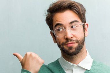 Genç yakışıklı girişimci adam yüz tatlı bir şey, doğal ve rahat sunan sürpriz gülümseyen tarafına işaret