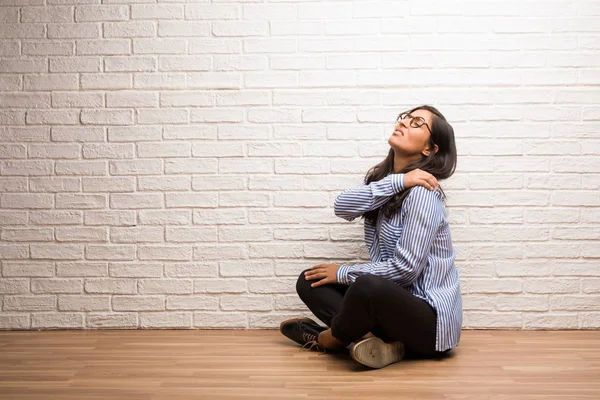 Jonge Indiase Vrouw Zitten Tegen Een Bakstenen Muur Met Rugpijn — Stockfoto