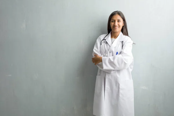 Young indian doctor woman against wall crossing arms