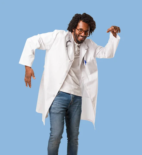 Handsome african american medical doctor Listening to music, dancing and having fun, moving, shouting and expressing happiness, freedom concept