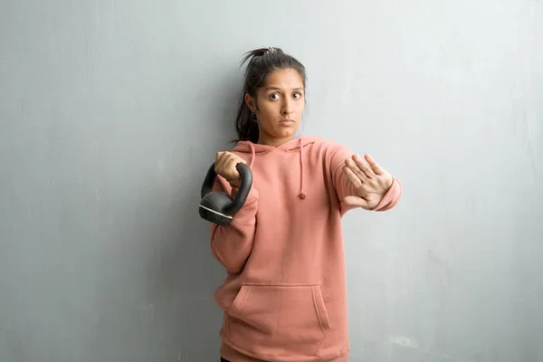 Молода Спортивна Індійська Жінка Проти Стіни Серйозна Рішуча Поклавши Руку — стокове фото