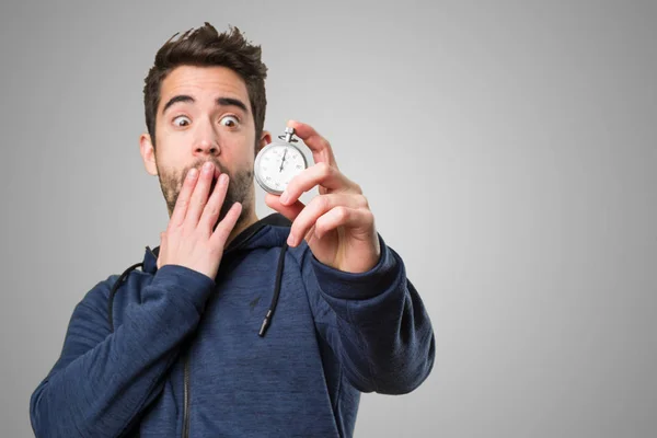 Joven Sorprendido Sosteniendo Cronómetro Sobre Fondo Gris — Foto de Stock