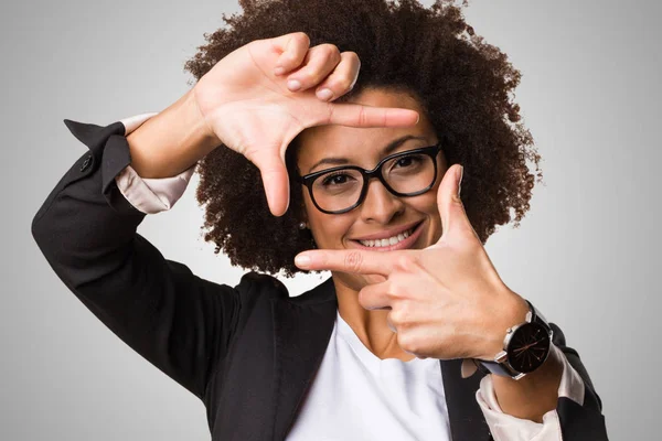 black business woman doing frame gesture on gray background